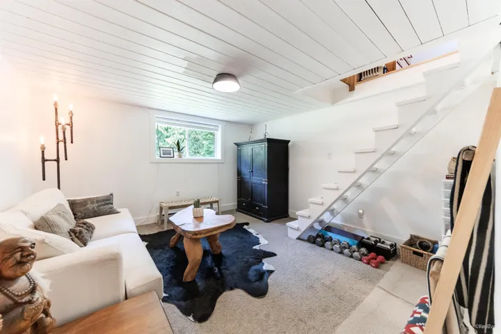 Living room with wooden ceiling and light carpet