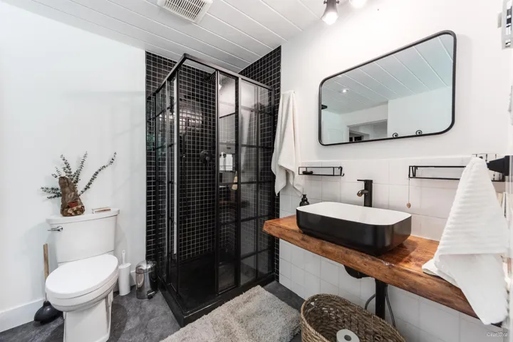 Full bath with vanity, a stall shower, and tile walls