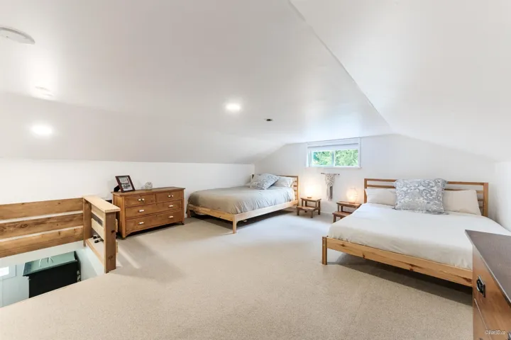 Bedroom featuring light carpet and lofted ceiling
