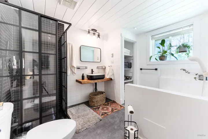 Bathroom with a stall shower, tile walls, vanity, and wooden ceiling