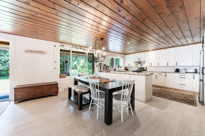 Dining space with wooden ceiling and light wood-style flooring