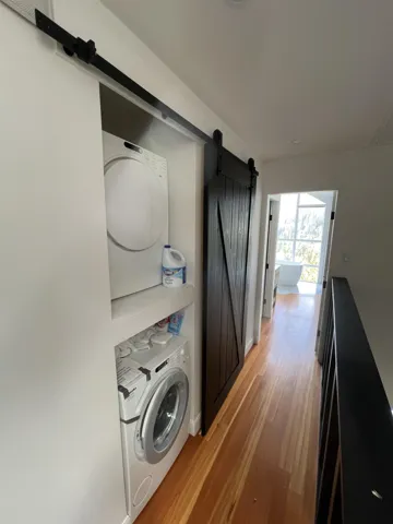 Laundry room featuring a barn door and light wood finished floors