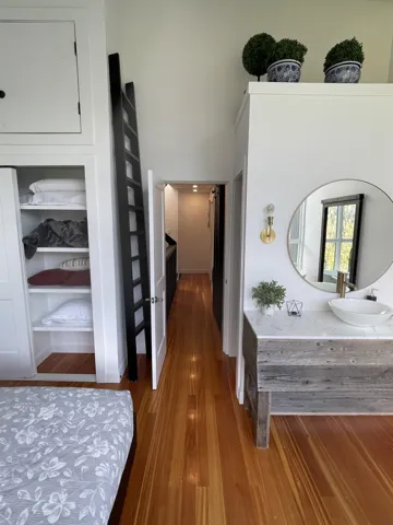 Hall with dark wood-style floors and a sink