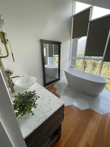 Bathroom with a freestanding tub, vanity, and wood finished floors