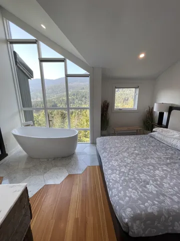 Bedroom with a wooded view, recessed lighting, and light wood-type flooring