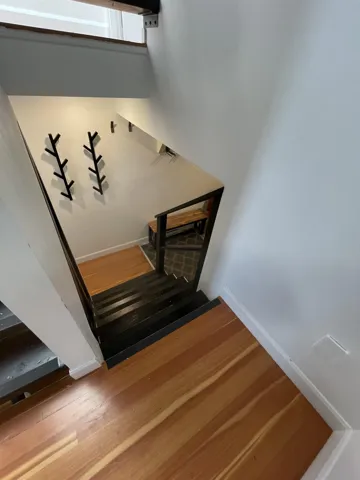 Staircase with baseboards and wood finished floors