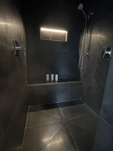 Bathroom featuring tiled shower and tile patterned floors