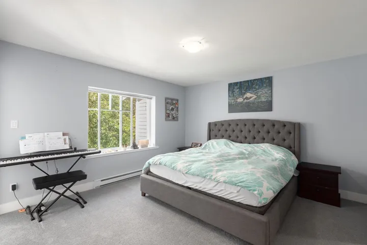 Bedroom with baseboard heating and carpet flooring