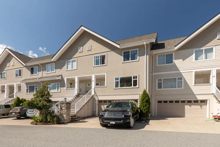Traditional home with stairway, driveway, a garage, and a shingled roof