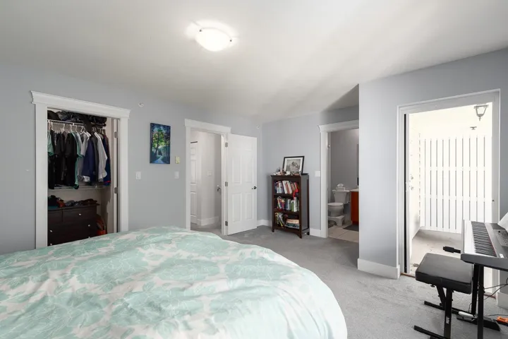 Bedroom featuring light carpet and connected bathroom