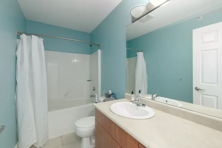 Full bath featuring vanity, shower / tub combo, and tile patterned flooring