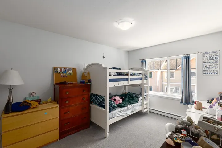 Bedroom featuring carpet flooring and a baseboard heating unit