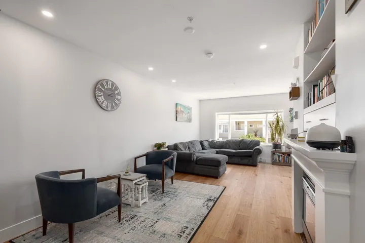 Living area with light wood-type flooring and recessed lighting