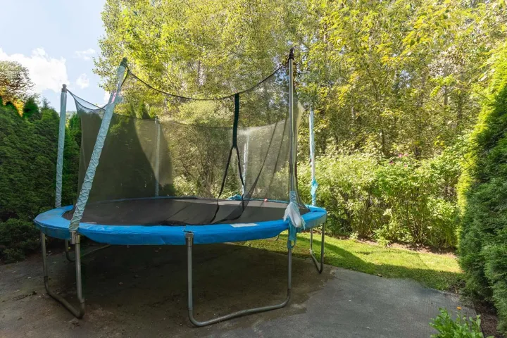 View of patio / terrace with a trampoline and a view of trees