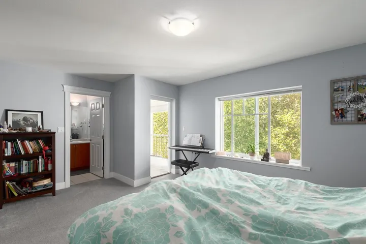 Bedroom featuring light colored carpet and ensuite bathroom