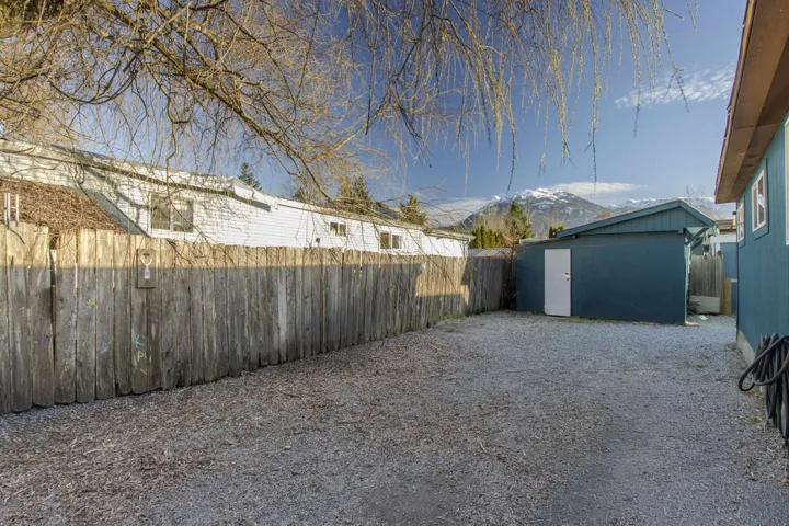 Fenced backyard featuring an outbuilding and a mountain view