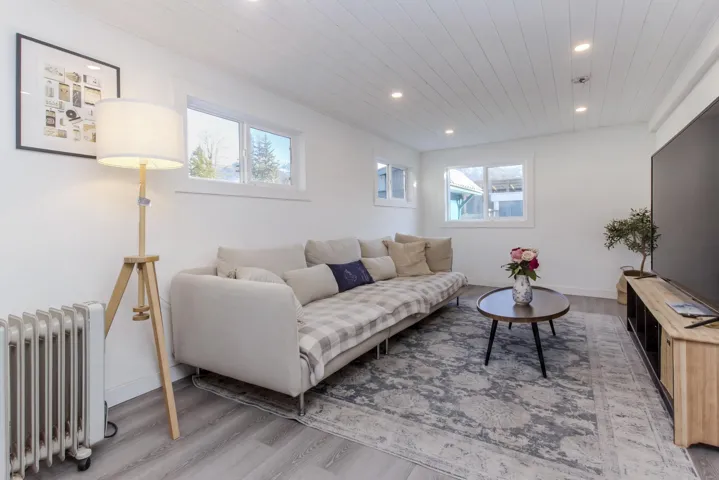 Living area with radiator, light wood-style floors, wooden ceiling, and recessed lighting