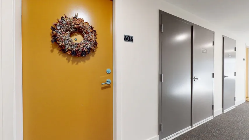 Corridor featuring carpet floors and baseboards