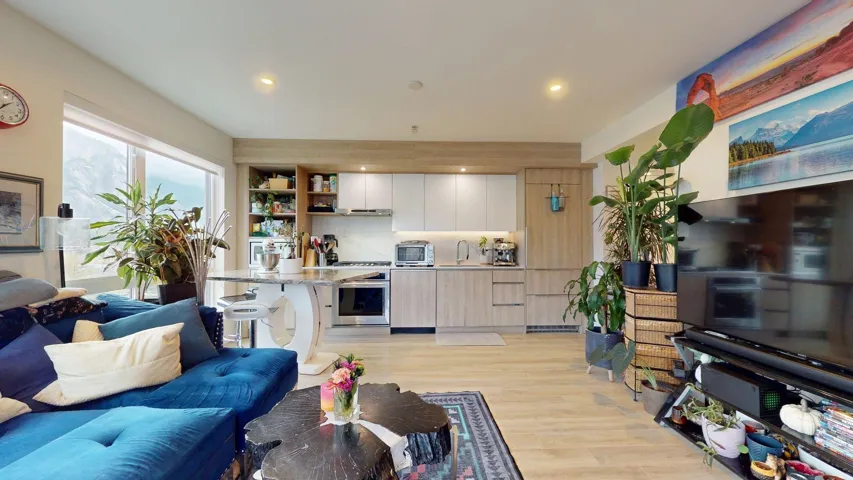 Living room with light wood-style flooring and recessed lighting