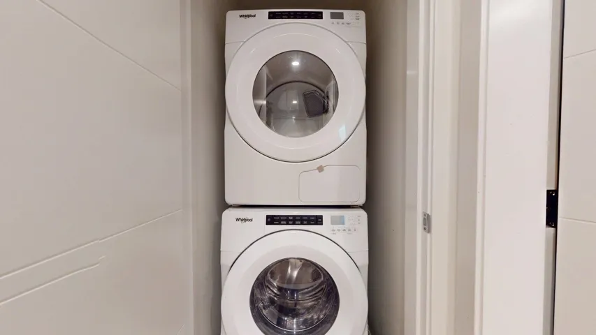 Washroom with stacked washer and clothes dryer