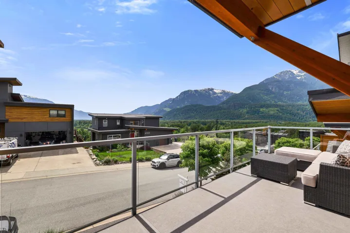 Spacious balcony with glass railings and wood beam accents