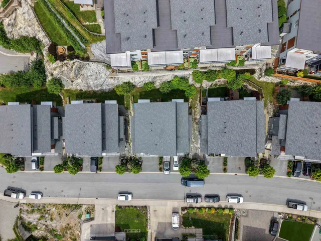 Aerial perspective of a multi-unit residential development with uniform gray shingle roofs