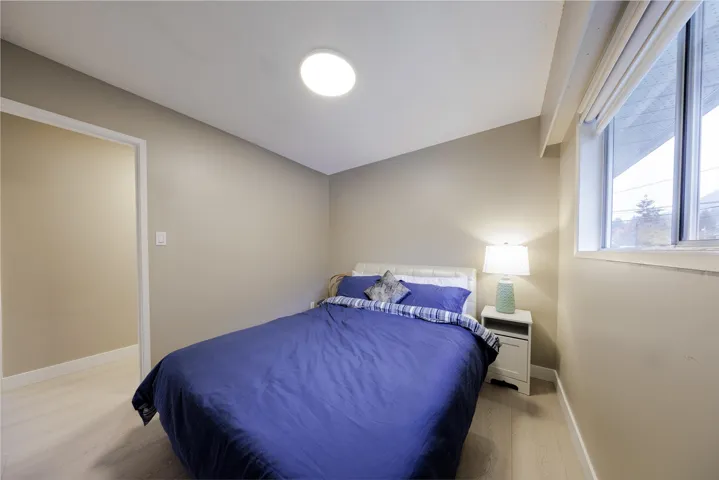 Neutral-toned walls, wood-finish flooring, and a flush-mount ceiling light fixture