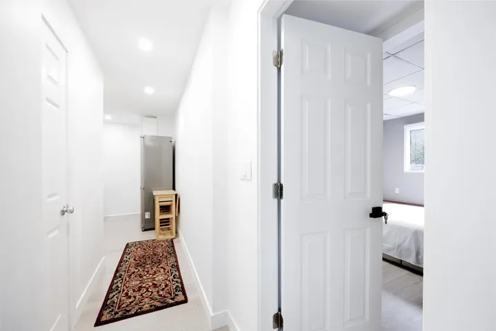White six-panel interior doors with matte black hardware and recessed ceiling lighting