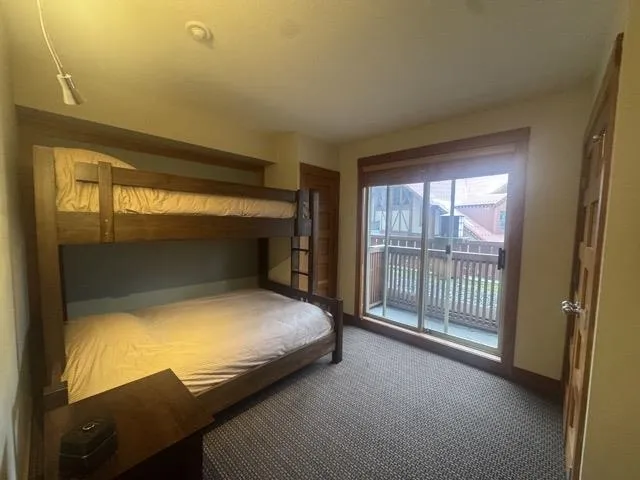 Unfurnished bedroom featuring access to outside and carpet flooring