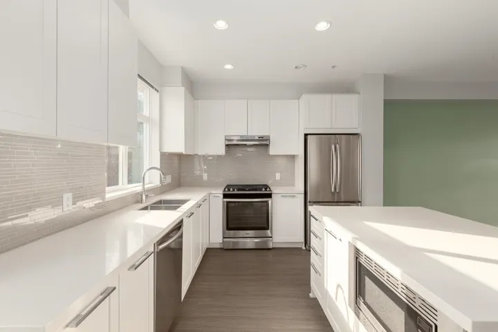Kitchen featuring stainless steel appliances, white cabinetry, a kitchen island, and recessed lighting