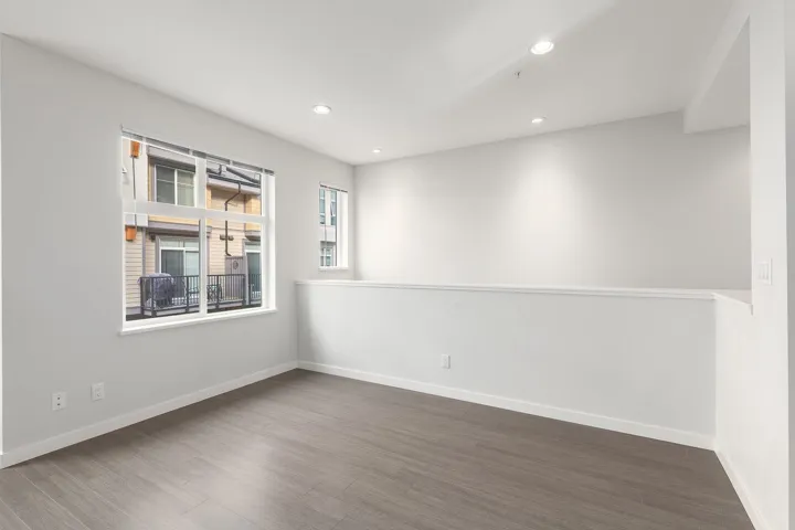 Open concept room featuring wood-finish flooring, recessed lighting, and a half-wall partition