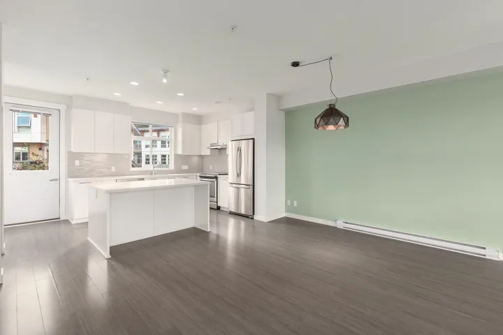 Contemporary kitchen and living area featuring wood-finish flooring