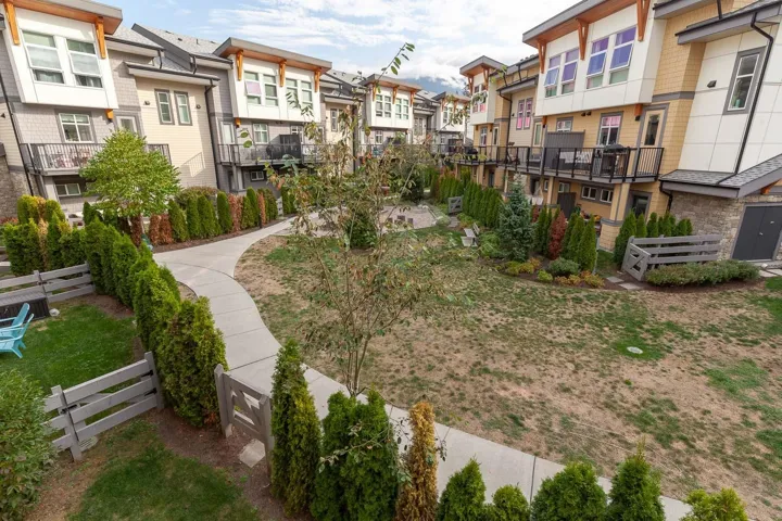 Central courtyard featuring a concrete pathway, mature trees, and established hedges