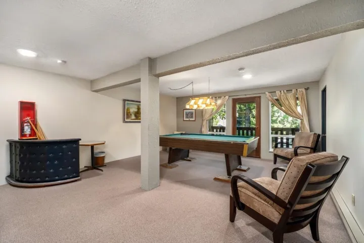 Recreation room featuring carpet flooring, recessed lighting, exposed beams, and a wood-frame glass panel door
