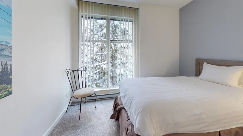 Bedroom with carpet flooring and a baseboard heating unit