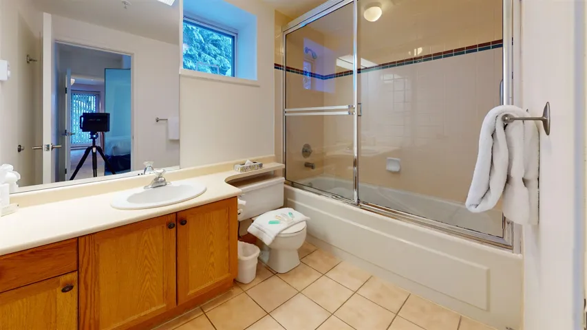 Full bathroom featuring vanity, combined bath / shower with glass door, and light tile patterned floors