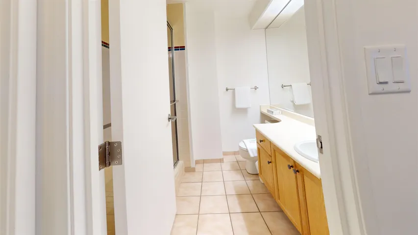 Bathroom with light tile patterned floors, vanity, and a shower stall
