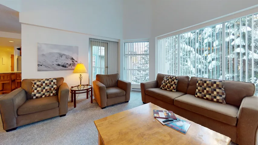 Carpeted living room with a high ceiling