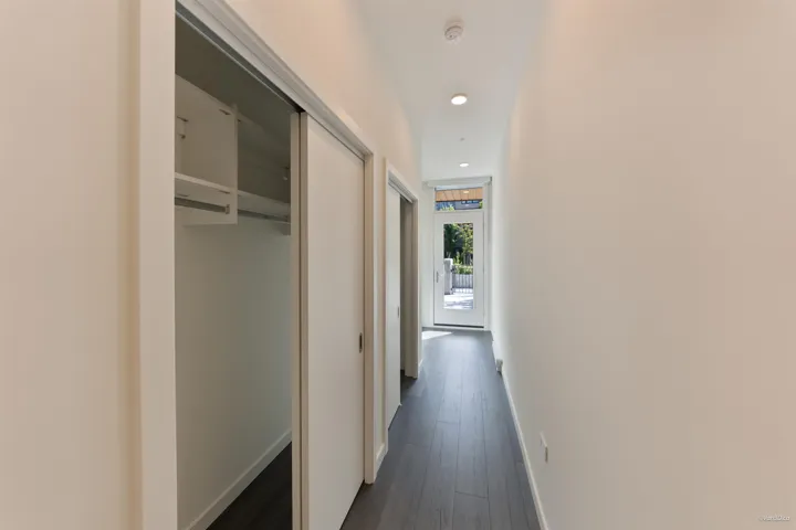 Hallway featuring wood-finish flooring, recessed lighting, and a sliding closet door