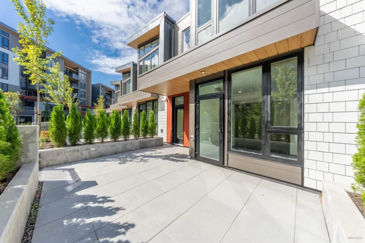 Expansive outdoor patio with concrete pavers and a built-in planter