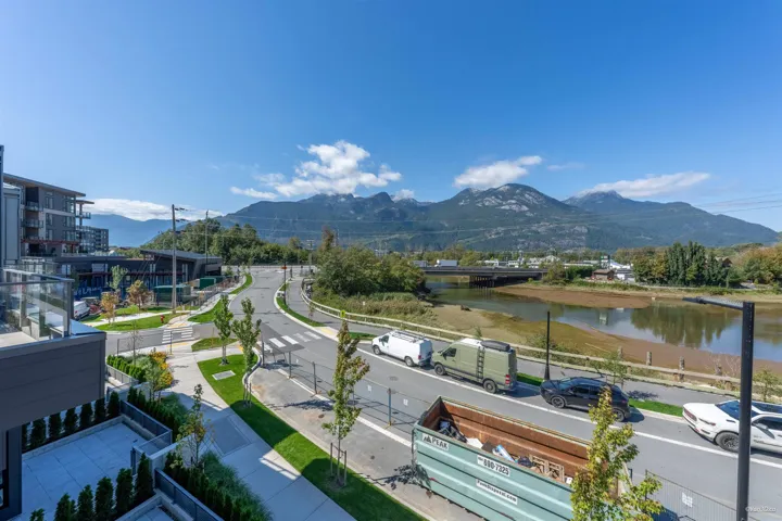 Modern residential architecture with a private balcony, offering a prominent mountain backdrop and a riverine landscape