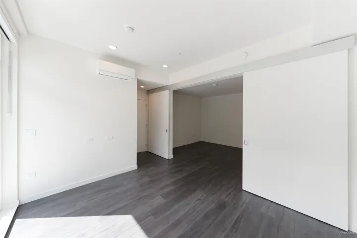 Wood-finish flooring, recessed lighting, white walls, and a mini-split AC unit