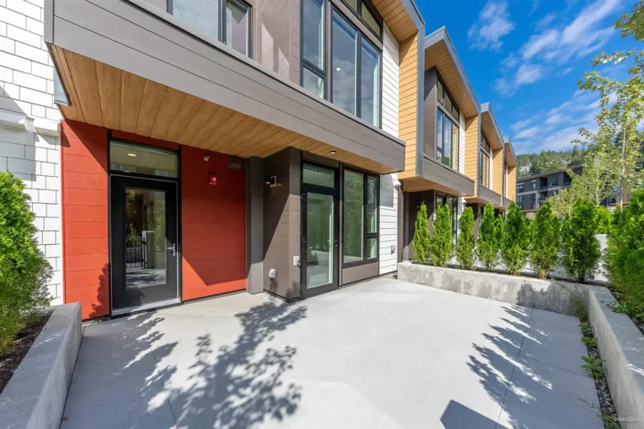 Modern exterior architecture with red panel accents, wood-finish soffit, and large windows
