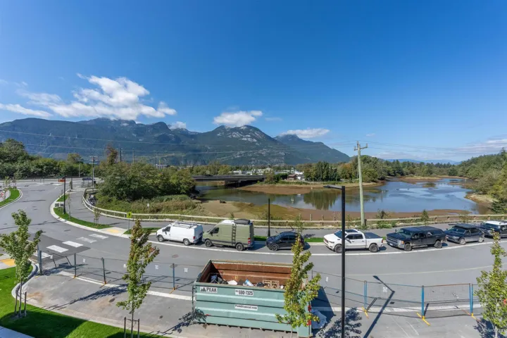 Expansive mountain range, natural water feature, and mature trees provide a scenic backdrop