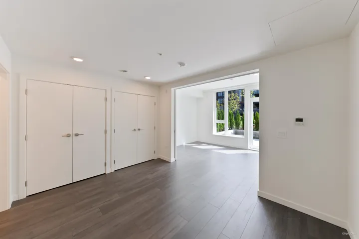 Wood-finish flooring throughout, recessed lighting, and bright white walls