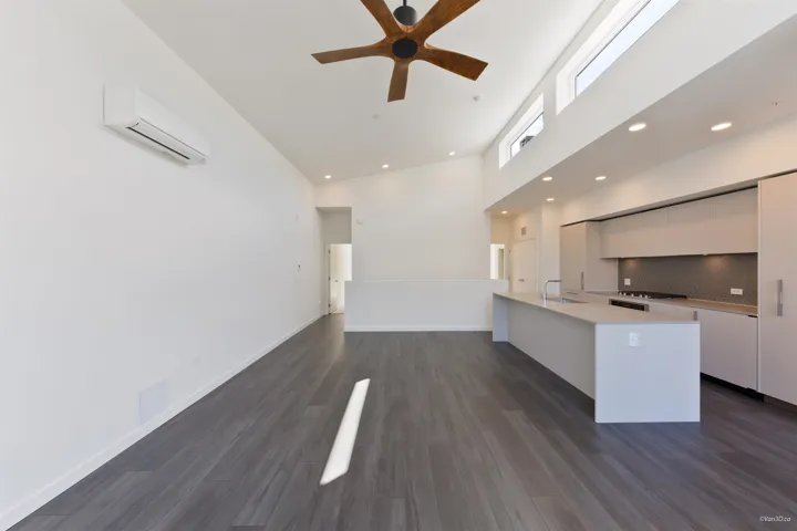 Open-concept living area with vaulted ceilings, wood-finish flooring, a modern ceiling fan, and recessed lighting
