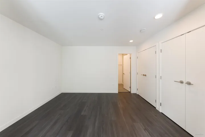 Recessed lighting, wood-finish flooring, and white walls