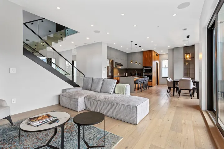 Living room with light wood-style flooring, recessed lighting, and stairway