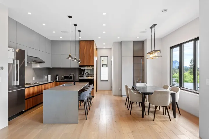 Kitchen featuring modern cabinets, appliances with stainless steel finishes, under cabinet range hood, a sink, and light wood finished floors