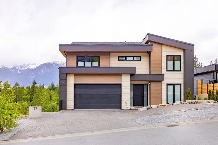 Contemporary home with decorative driveway, an attached garage, and a mountain view